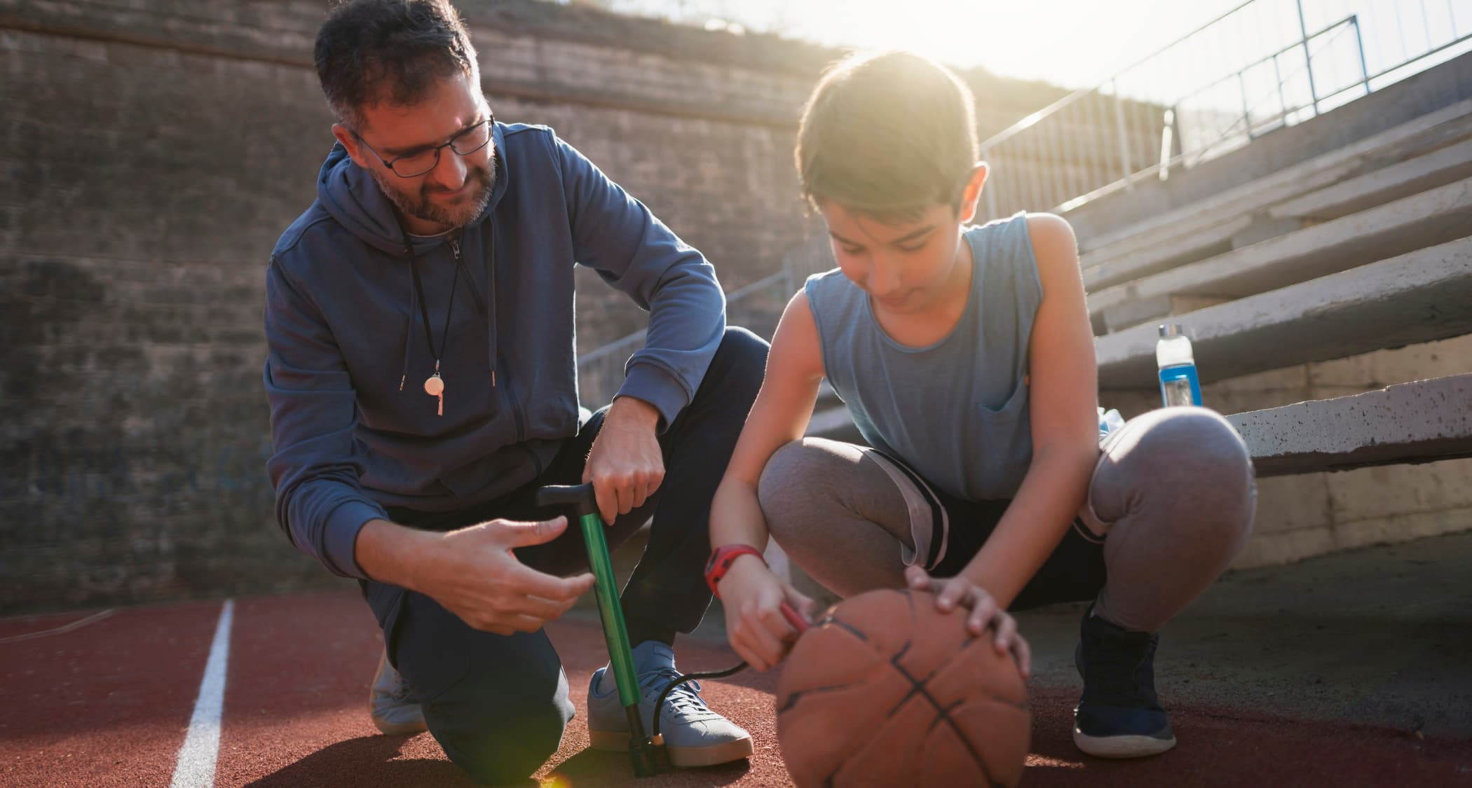 Father and son inflating a basketball